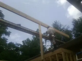 Carpenter setting a ridge beam over a new addition frame — Ice Dam Removal by Roofing Brothers in South Bound Brook