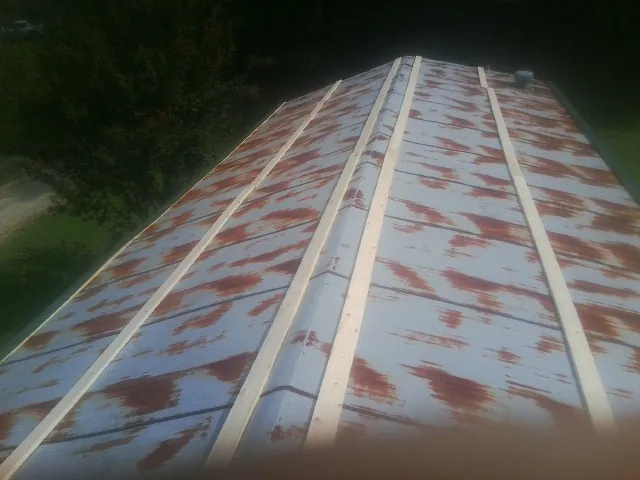 Rusted metal roof panels with new wood purlins before replacement — Storm Damage Roof Repair in South Bound Brook by Roofing Brothers